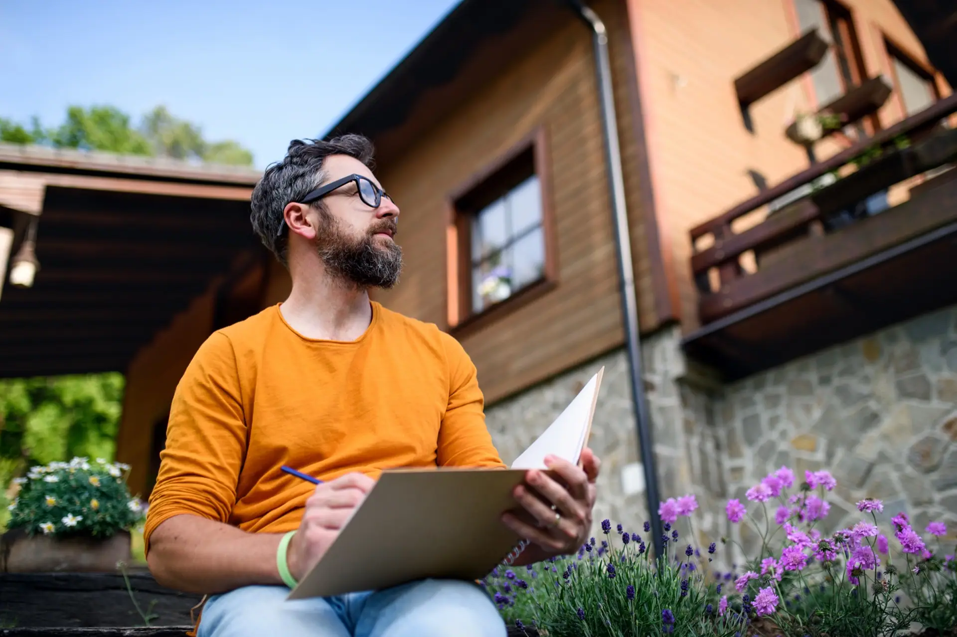 Appraiser taking notes outside a home on a sunny afternoon